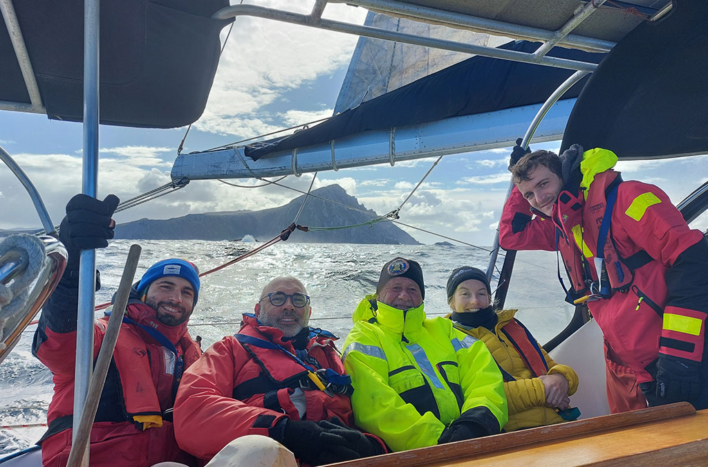 Les passagers posent avec le cap horn derrière eux