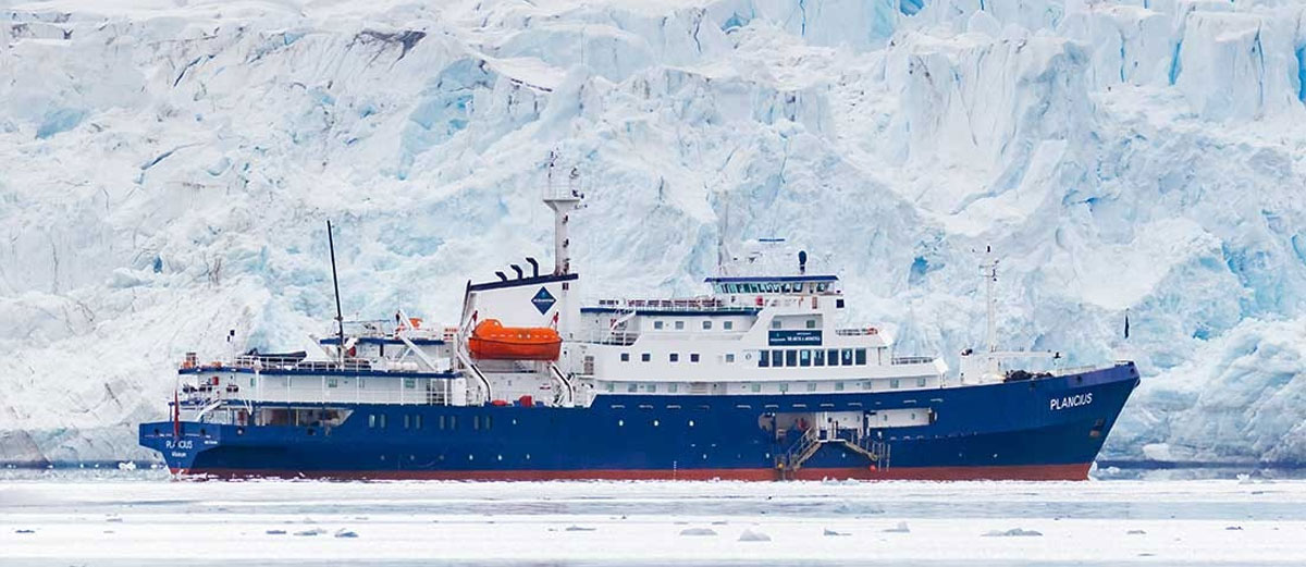 Le Plancius vu de profil devant un glacier