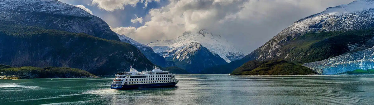 un bateau de croisiere australis navigue dans les fjords de la cordillere darwin