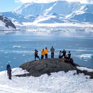 des passagers sur un rocher regardent l'antarctique