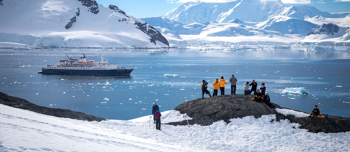 le groupe en promenade regarde le bateau en contrebas dans la baie danco