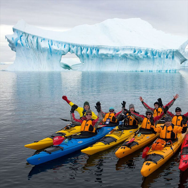 un groupe de kayak devant un iceberg