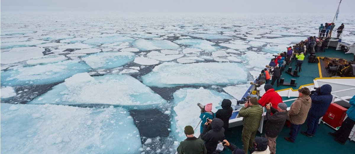 les voyageurs sur le pont du bateau dans une mer de glace au nord du Spitzberg