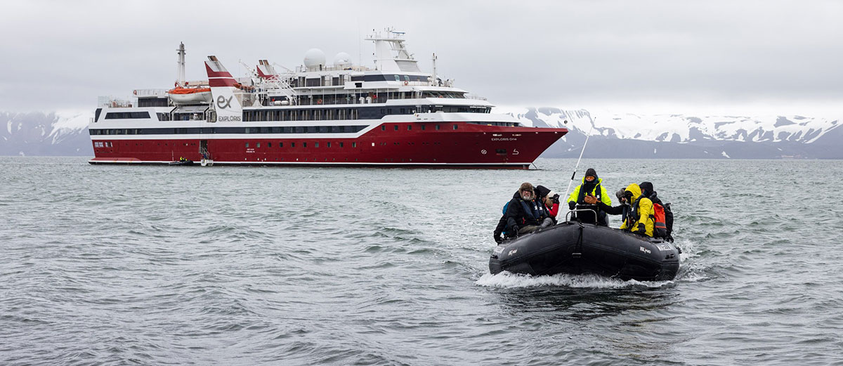 un zodiac arrive en face avec le bateau Exploris One derrière