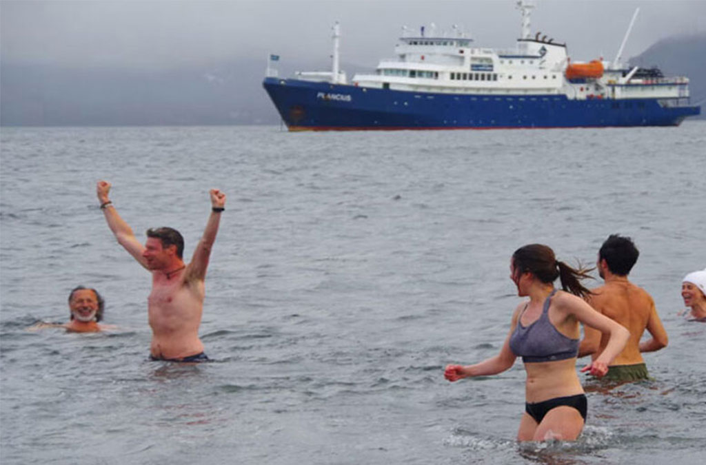 des baigneurs en antarctique s'amusent dans l'eau